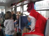 Der Nikolaus verteilt während der Fahrt an die Kinder und Erzieherinnen des Patenkindergartens Geschenke.